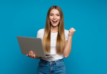 A young woman with long blonde hair, wearing a white t-shirt and blue jeans, holds a silver laptop and raises her fist with a big smile in front of a vibrant background.

