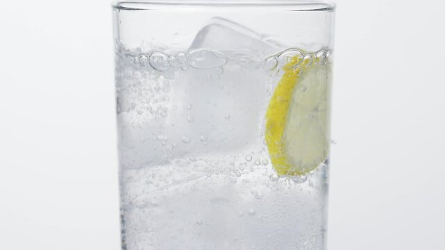 Pouring Soda in glass, ice and lemon, white background, 4k, 120fps