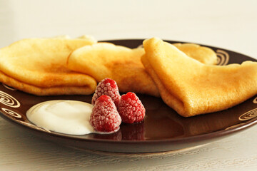 Pancakes with frozen raspberries and sour cream
