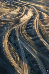 Aerial view of winding roads in desert landscape showcasing curving paths, sunset light, and natural patterns, perfect for travel and adventure photography.