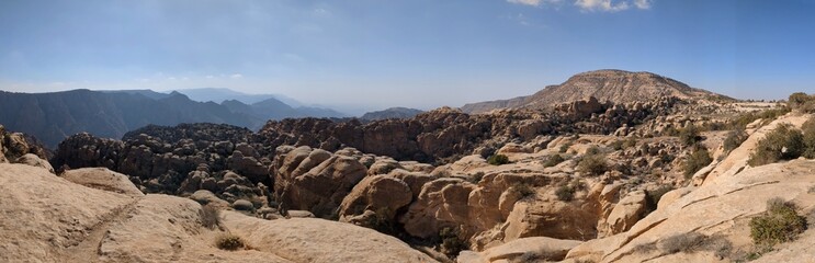 Panoramic view of Dana Valley in Jordan, showcasing rocky mountains and desert landscapes on the Jordan Trail. A breathtaking scene for hikers and adventurers in the Arabian wilderness.	
