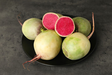 Whole and cut fresh turnips on grey table, closeup