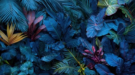 Dense layers of tropical leaves showcase rich green and blue hues with splashes of red and yellow. The composition highlights the beauty of vegetation in a vibrant ecosystem