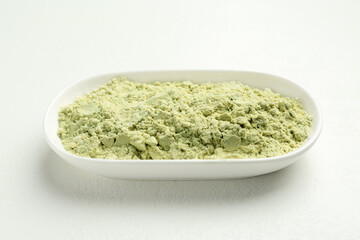 Dry wasabi powder on white textured table, closeup