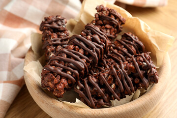 Delicious chocolate puffed rice bars on wooden table, closeup