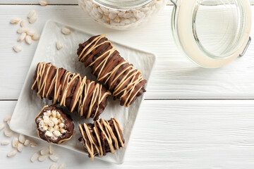 Delicious chocolate puffed rice bars on white wooden table, flat lay. Space for text