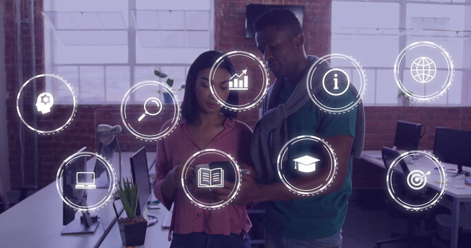 Image of business icons over diverse colleagues discussing work in office - Powered by Adobe