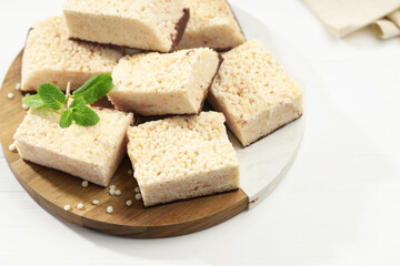 Delicious puffed rice bars and mint on white wooden table, closeup