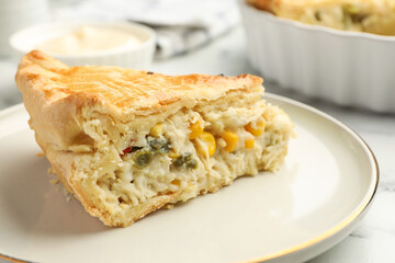 Piece of tasty homemade pie with chicken and vegetables on white table, closeup