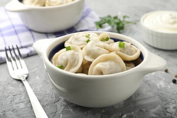 Delicious dumplings served on grey table, closeup