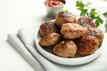 Delicious patties with green onions, parsley and ketchup on white table, closeup