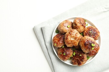 Delicious patties with green onions on white table, top view. Space for text