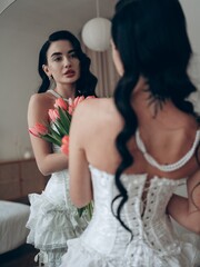 Sexy woman in bridal erotic bodysuit posing in bedroom against mirror with herself reflection...