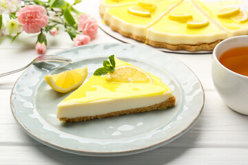 Delicious cheesecake with lemon curd served on white wooden table, closeup