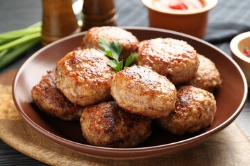Delicious patties with parsley on table, closeup