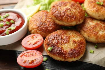 Delicious patties with green onions, tomato and ketchup on table, closeup