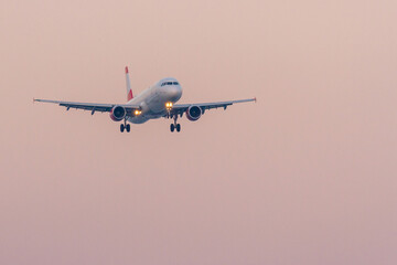 Passenger airplane with lights in evening sky on landing. Larnaca, Cyprus 