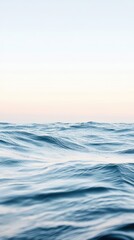 Obraz premium Calm Ocean Waves Under Soft Blue Sky at Dawn or Dusk