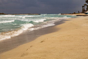Turquoise water and leaden sky in stormy weather on an empty beach.  Nissi Beach in Ayia Napa. January. Mediterranean, Cyprus