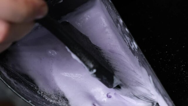 Mixing powder or paint for lightening or bleaching and oxidizing powder with a brush on blonde hair with a close-up