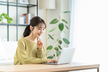 リビングでパソコンを使う若い女性