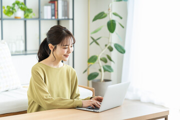 リビングでパソコンを使う若い女性