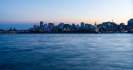 Naklejka premium View of downtown Montreal city skyline and Saint Lawrence River at dusk, Quebec, Canada.