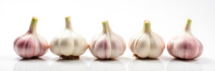 Obraz premium Fresh garlic bulbs arranged in a row, green stems visible on white background , garlic, close-up
