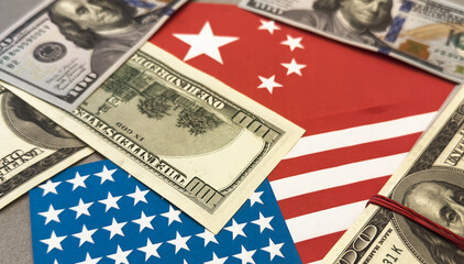 Us and china flags with currency symbolizing economic relations.