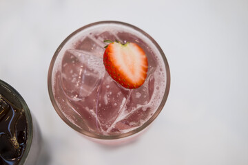 Iced cold strawberry soda with fresh slice strawberry on top