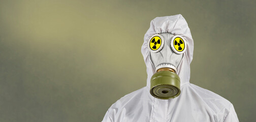 A man in a gas mask and protective suit. Environmental pollution concept. Dirty air with dust and noise, grunge effect.