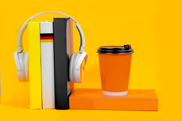 Learning German, headphones and textbooks. Listening to books of German literature, audiobook. Flag...