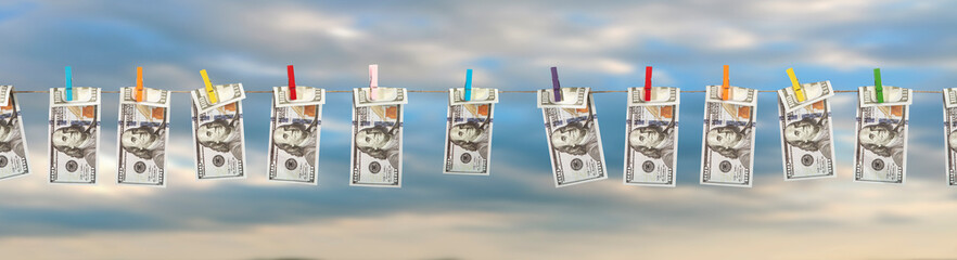 Concept of money laundering. Washed dollar bills hanging on clothespins to dry in the wind. Illegal...