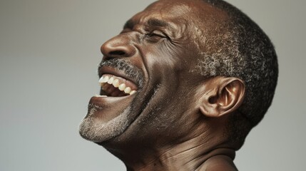 The image shows an older man laughing heartily.