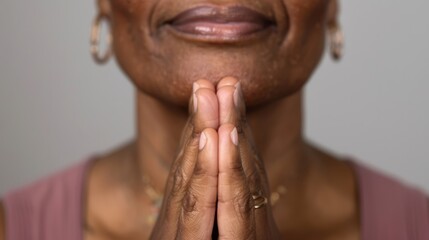 Fototapeta premium Portrait of An Afro retired woman with prayer gesture looking at the camera.