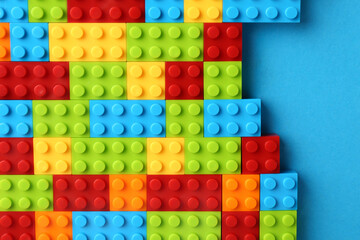 Constructor toy. Many colorful building blocks on light blue background, top view