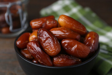 Tasty dried dates in bowl on table, closeup