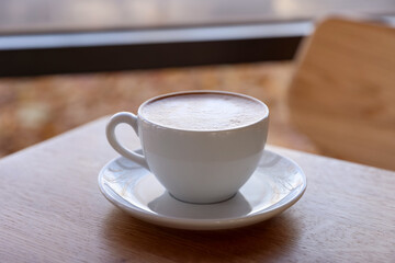Cup of aromatic coffee on wooden table in cafe, closeup