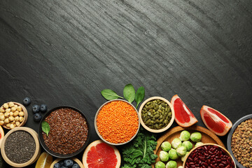 Different superfood products on black table, flat lay. Space for text