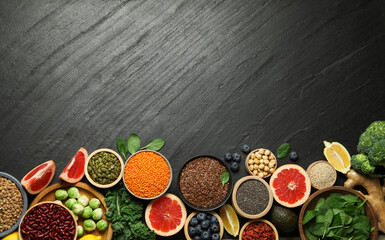 Different superfood products on black table, flat lay. Space for text