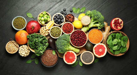 Different superfood products on black table, flat lay