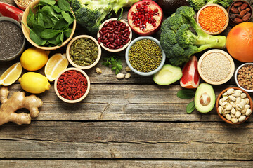 Different superfood products on wooden table, flat lay. Space for text
