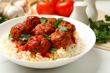 Delicious meatballs with rice, sauce and parsley on white table, closeup