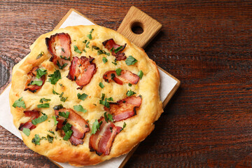 Delicious focaccia bread with bacon and parsley on wooden table, top view