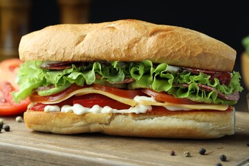 Delicious baguette sandwich with salami and cheese on wooden table