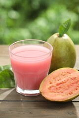 Refreshing guava juice and fresh fruits on wooden table, closeup