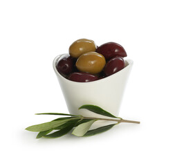 Delicious marinated olives in bowl and leaves isolated on white