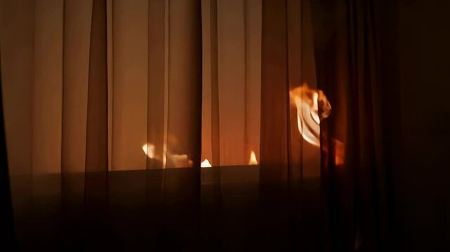 Apartment fire caused by unextinguished candle ignites curtains and surrounding area at night