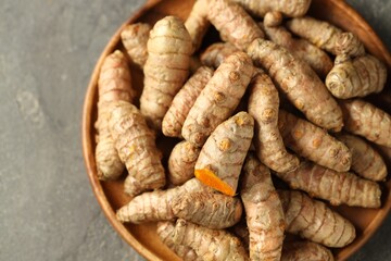 Raw tumeric rhizomes on grey table, top view