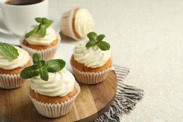 Delicious carrot cupcakes with mint on light textured table, closeup. Space for text